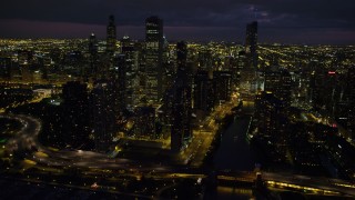 AX0003_164 - 4.8K aerial stock footage of flying by Chicago River and downtown skyscrapers on a cloudy night, Downtown Chicago, Illinois