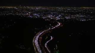 AX0004_010E - 5K aerial stock footage of following Highway 101 at night toward Hollywood, California