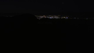 AX0004_012E - 5K aerial stock footage orbit radio tower atop the Hollywood Hills at night, California