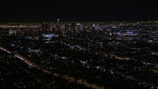 AX0004_018E - 5K aerial stock footage tilt and reveal Downtown Los Angeles skyscrapers at night, California