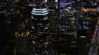 AX0004_030 - 5K aerial stock footage orbit and fly away from Figueroa at Wilshire at night in Downtown Los Angeles, California
