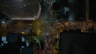 AX0004_046E - 5K aerial stock footage bird's eye view of South Figueroa Street at night in Downtown Los Angeles, California