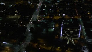 AX0004_055 - 5K aerial stock footage pan across streets and skyscrapers at night in Downtown Los Angeles, California