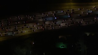 AX0004_069E - 5K aerial stock footage bird's eye view of heavy freeway traffic at night in Hollywood, California