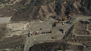 AX0005_016 - 5K aerial stock footage video of equipment at a quarry in Canyon Country, California