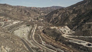 AX0005_018 - 5K aerial stock footage follow road to a tunnel through mountain in the San Gabriel Mountains, California 