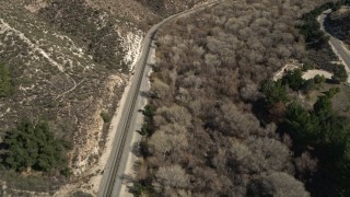 AX0005_022 - 5K aerial stock footage of a railroad track through Santa Clarita Countryside in California