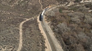AX0005_024 - 5K aerial stock footage reveal and approach passenger train in Santa Clarita, California