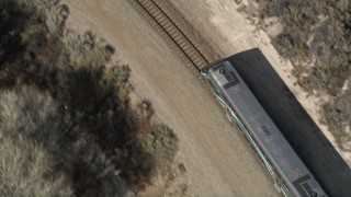 AX0005_027 - 5K aerial stock footage of tracking the front of a commuter train in Santa Clarita, California