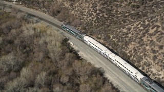 AX0005_028E - 5K stock footage aerial video track Metrolink train traveling near Santa Clarita, California