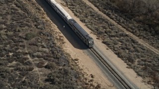 AX0005_030 - 5K aerial stock footage of a Metrolink train near Santa Clarita, California