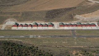 AX0005_047 - 5K aerial stock footage approach small airplane hangars at Agua Dulce Airpark, California