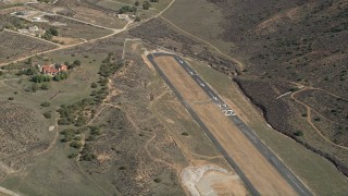 AX0005_048 - 5K aerial stock footage orbit runways at a desert airfield in Agua Dulce, California