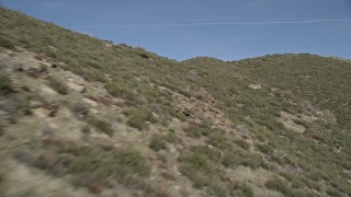 AX0005_053E - 5K aerial stock footage fly low over arid mountain slopes in the Mojave Desert, California