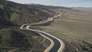 AX0005_063 - 5K stock footage aerial video fly low over the desert to reveal California Aqueduct in Mojave Desert