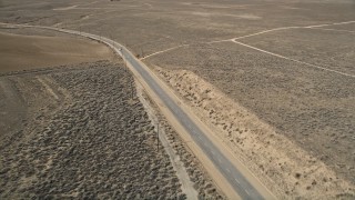 AX0005_067 - 5K stock footage aerial video orbit desert road and white car in Antelope Valley, California