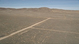 AX0005_068 - 5K aerial stock footage approach and fly over dirt roads in the desert in Antelope Valley, California