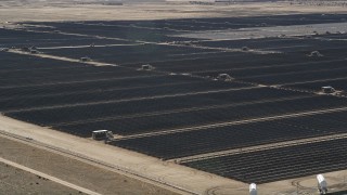 AX0005_080 - 5K stock footage aerial video orbit a large array of solar panels in the desert in Antelope Valley, California