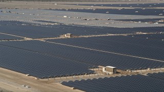 AX0005_084E - 5K stock footage aerial video orbit rows of panels at a massive solar array in the Mojave Desert, California