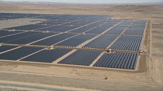 AX0005_090E - 5K aerial stock footage orbit a large solar energy array in the Mojave Desert, California