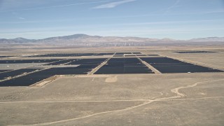 AX0005_094 - 5K aerial stock footage of a reverse view of a solar energy farm in the Mojave Desert, California