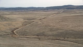 AX0005_098 - 5K aerial stock footage orbit a dirt road through the desert in Antelope Valley, California