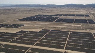 AX0005_109 - 5K aerial stock footage fly over solar panels to a second group of panels at a desert array in Antelope Valley, California