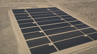 AX0005_111 - 5K aerial stock footage orbit long rows of solar panels at an energy array in the Mojave Desert, California