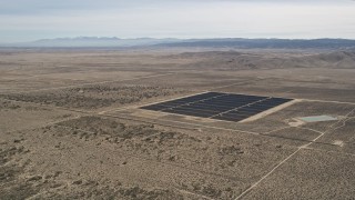 AX0005_114 - 5K stock footage aerial video orbit small group of panels at a solar energy array in the Mojave Desert, California