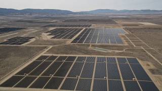 AX0005_118 - 5K stock footage aerial video approach and fly over panels in a solar energy array in the Mojave Desert, California