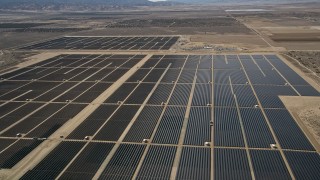 AX0005_119E - 5K aerial stock footage approach and fly over Mojave Desert solar energy array in California