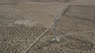 AX0005_128 - 5K aerial stock footage orbit of a single windmill in the Mojave Desert of California