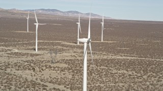 AX0005_129E - 5K aerial stock footage orbit top of a windmill in the Mojave Desert, California