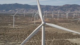 AX0005_131E - 5K aerial stock footage orbit of a windmill at a desert wind farm in Antelope Valley, California