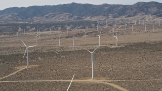 AX0005_143 - 5K aerial stock footage orbit a large group of windmills in the Mojave Desert of California