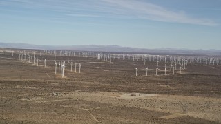 AX0006_006 - 5K aerial stock footage pan across rows of windmills at desert wind farm in Antelope Valley, California