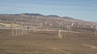 AX0006_007 - 5K aerial stock footage pan to a row of windmills at a large desert wind farm in Antelope Valley, California
