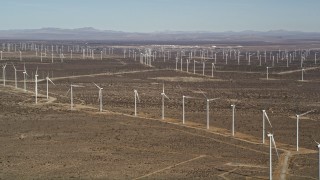 AX0006_008E - 5K aerial stock footage pan to line of windmills at large wind farm in the Mojave Desert, California