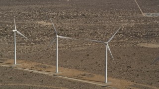 AX0006_010 - 5K aerial stock footage approach a pair of windmills at a desert wind farm in Antelope Valley, California
