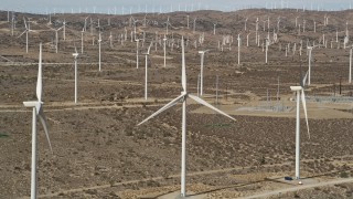 AX0006_014 - 5K stock footage aerial video orbit a windmill at a desert wind farm in Antelope Valley, California