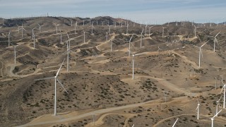 AX0006_019 - 5K aerial stock footage approach large group of windmills at desert wind energy farm in Antelope Valley, California