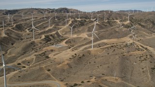 AX0006_020E - 5K stock footage aerial video of approaching a field full of windmills at a desert wind farm in Antelope Valley, California
