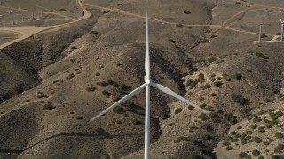 AX0006_024 - 5K aerial stock footage tilt to a bird's eye view of a single windmill at a desert wind farm in Antelope Valley, California
