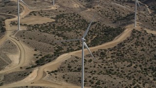 AX0006_026 - 5K aerial stock footage orbit a lone windmill at a desert wind farm in Antelope Valley, California