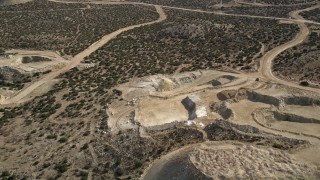 AX0006_028 - 5K aerial stock footage fly over a small quarry at a wind farm in the Mojave Desert, California