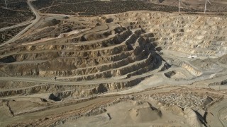 AX0006_034E - 5K aerial stock footage orbit a desert quarry pit in Antelope Valley, California