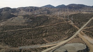 AX0006_036 - 5K aerial stock footage fly over quarry pit to reveal desert wind farm in Antelope Valley, California