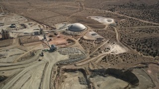AX0006_037 - 5K aerial stock footage orbiting above quarry buildings in the Mojave Desert, California