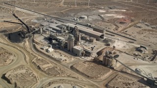 AX0006_038 - 5K stock footage aerial video orbit quarry buildings in the Mojave Desert, California