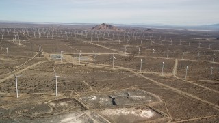 AX0006_039 - 5K aerial stock footage approach a wind energy farm with rows of windmills in the Mojave Desert, California